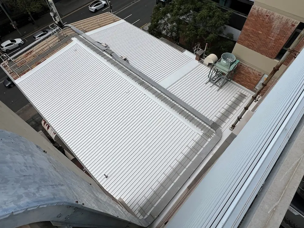 New roof sheeting being installed over a telecommunications building, St Leonards